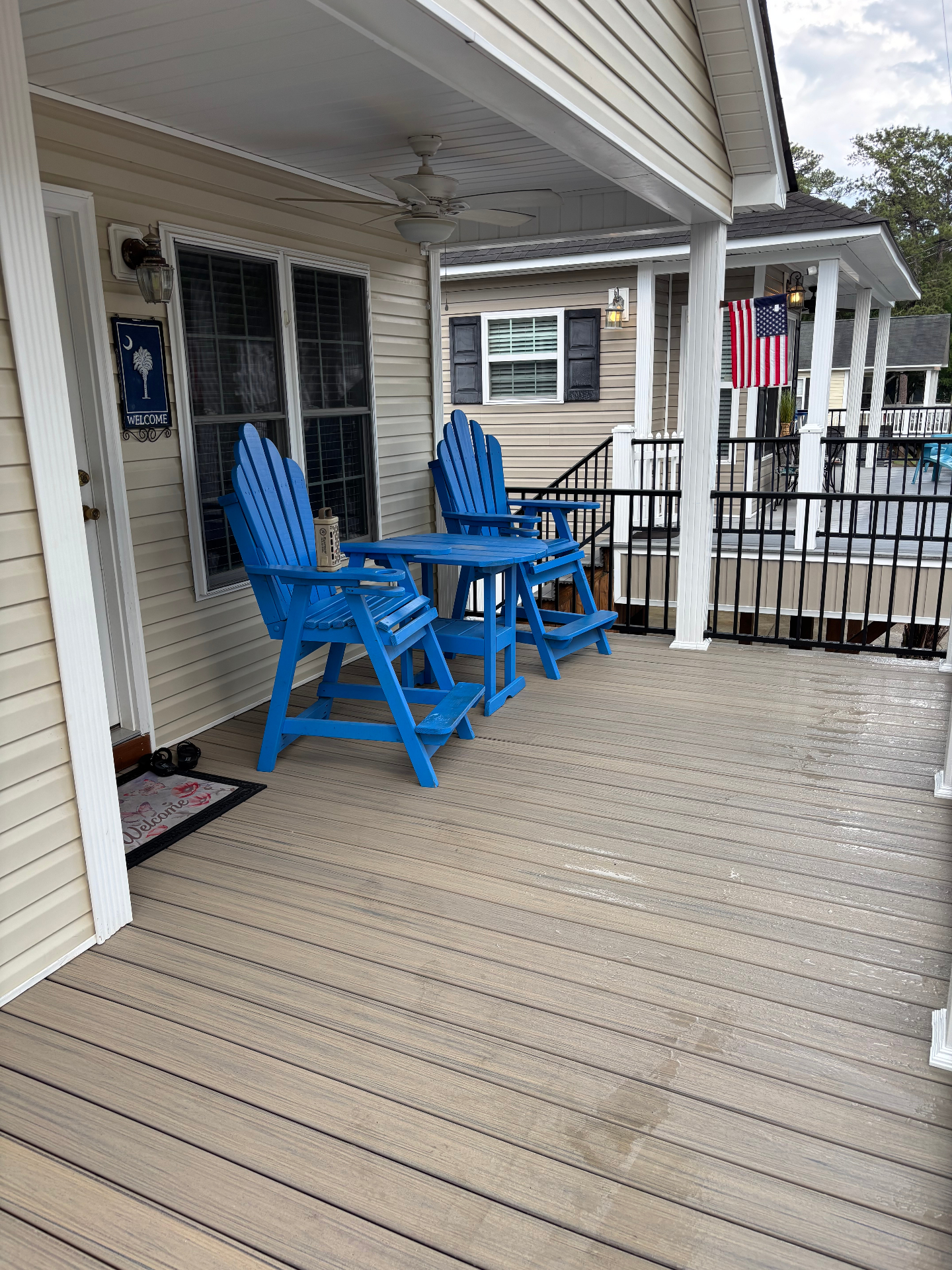 Front porch with blue Adirondack chairs and welcome mat