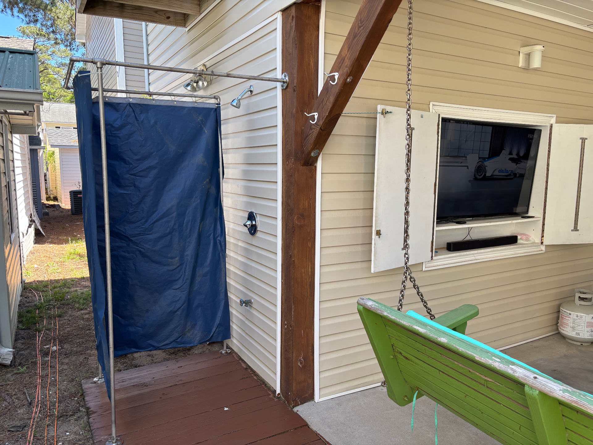 Outdoor shower next to the outdoor TV and swing